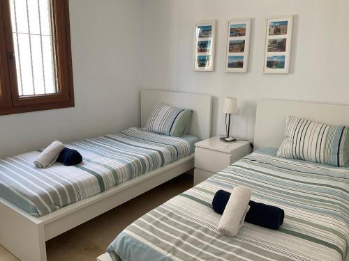 a bedroom with two beds with towels on them at Gound Floor Bungalow Jumilla III Playa Flamenca in Orihuela Costa