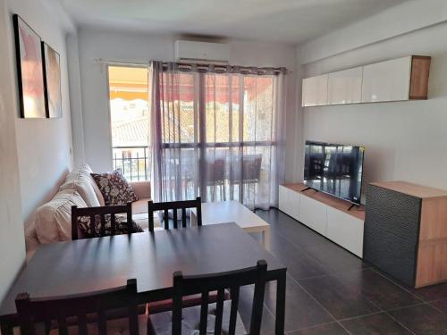 uma cozinha e sala de estar com uma mesa e um sofá em Apartamento con encanto y vistas al mar em Torre de Benagalbón