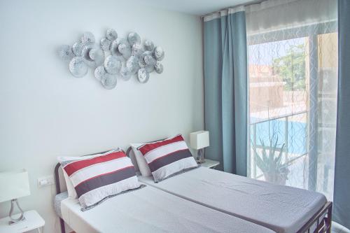 a white bedroom with a bed and a window at Lc Apartments - Sunrise in Santa Maria