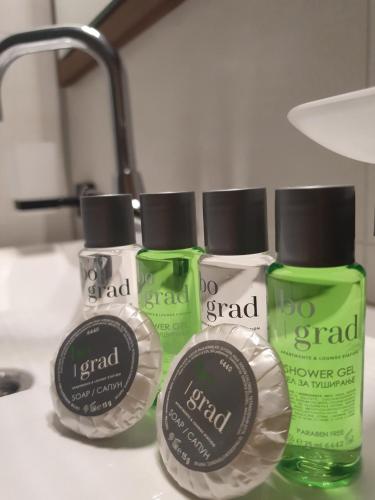 three bottles of detergent sitting on a bathroom counter at Hotel Bograd - Apartments & Lounge Station in Struga