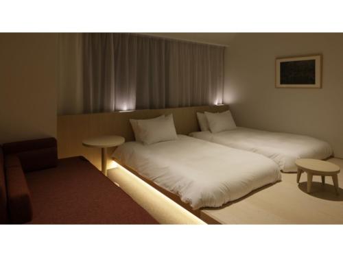 金沢市にあるSOKI KANAZAWA - Vacation STAY 40307vのベッド2台とテーブルが備わるホテルルームです。