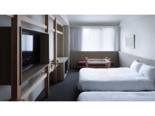 a hotel room with two beds and a flat screen tv at SOKI KANAZAWA - Vacation STAY 40333v in Kanazawa
