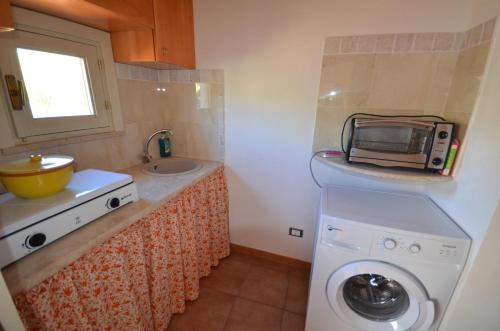 a small kitchen with a washing machine and a sink at Le Case di Zia Palma in Custonaci