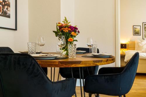 einen Esstisch mit Stühlen und eine Vase aus Blumen in der Unterkunft Suite für 4 mit Terrasse im Herzen der Innenstadt in Schwerin