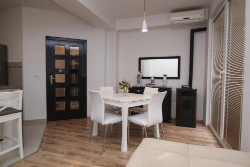 a dining room with a white table and white chairs at Ohrid City Apartments in Ohrid