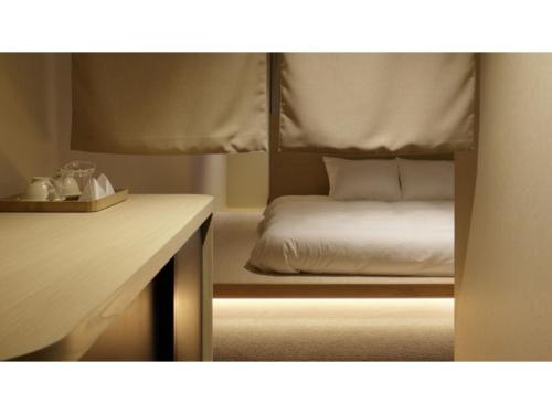 uma cama num quarto com uma secretária e uma cama sidx sidx em SOKI KANAZAWA - Vacation STAY 40329v em Kanazawa