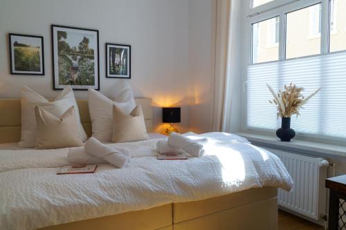 a bedroom with a white bed with two books on it at Suite für 4 mit Terrasse im Herzen der Innenstadt in Schwerin