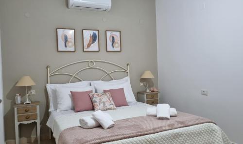 een slaapkamer met een bed met roze en witte kussens bij Cypress Garden House in Ayía Marína
