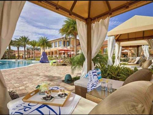 a patio with a table and chairs and a pool at AMAZING vacation house .Mins to Disney Regal oasks in Orlando
