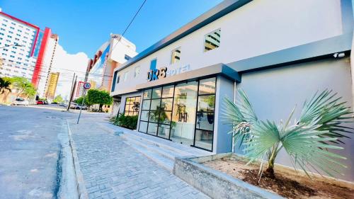 a building on a street with a palm tree in front at URB Hotel in Fortaleza