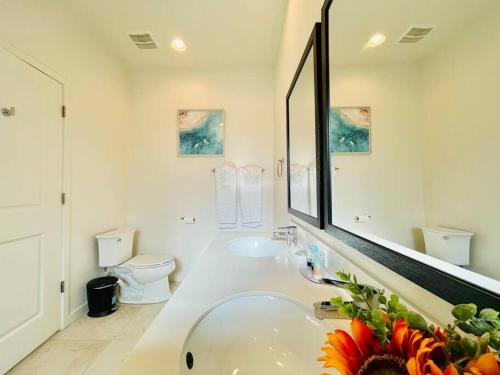 a white bathroom with a tub and a toilet at AMAZING vacation house .Mins to Disney Regal oasks in Orlando