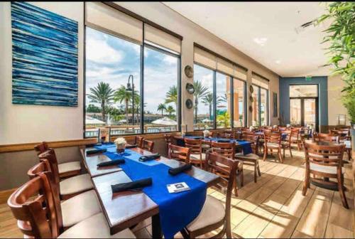a restaurant with blue tables and chairs and windows at AMAZING vacation house .Mins to Disney Regal oasks in Orlando