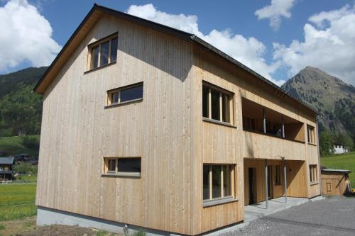 a house under construction with mountains in the background at Bergreich Appartement 5 in Schoppernau