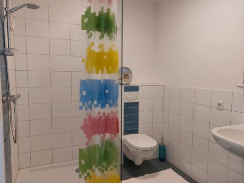 a bathroom with a toilet and a glass shower door at Medina B&B hartje Arnhem in Arnhem