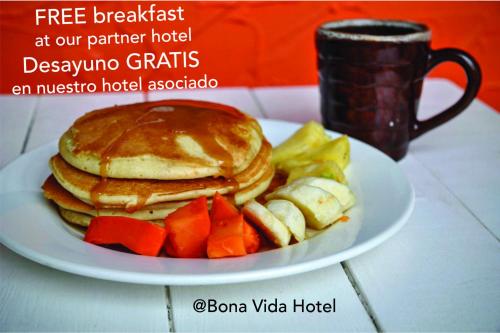 a plate of pancakes and vegetables and a cup of coffee at Bona Vida Apartments in Ríohacha