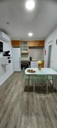 a kitchen with a table and a kitchen with a refrigerator at Casa Pejão Do Paraíso in Castelo de Paiva
