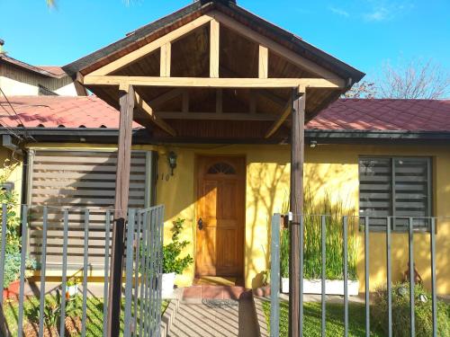 una casa con una puerta de madera y una valla en El hogar de Canela, en Talca