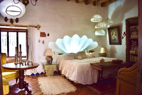 1 dormitorio con cama, mesa y ventana en Hotel boutique Arteaga, en Arteaga