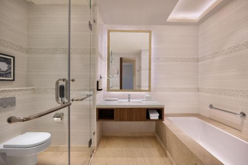 ein Badezimmer mit einer Badewanne, einem WC und einem Waschbecken in der Unterkunft Fairfield by Marriott Agra in Agra