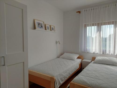 a small room with two beds and a window at Apartments Vlasici in Vlašići