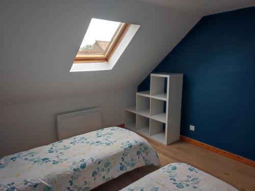 a attic bedroom with a bed and a window at La petite trapue in Desvres