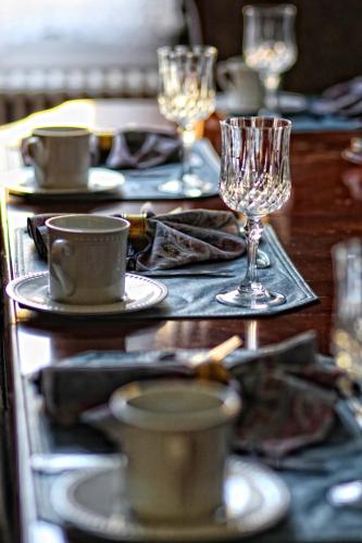 a table with plates and glasses on top of it at Wilbraham Mansion in Cape May