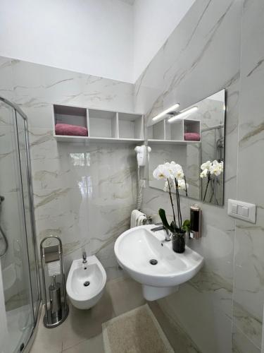 a white bathroom with a sink and a shower at Villa Latino in Vieste