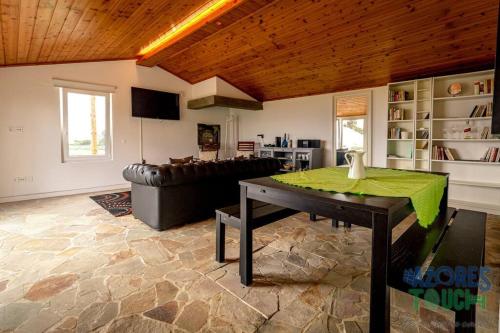 a living room with a table and a couch at Casa dos Calços in Angra do Heroísmo