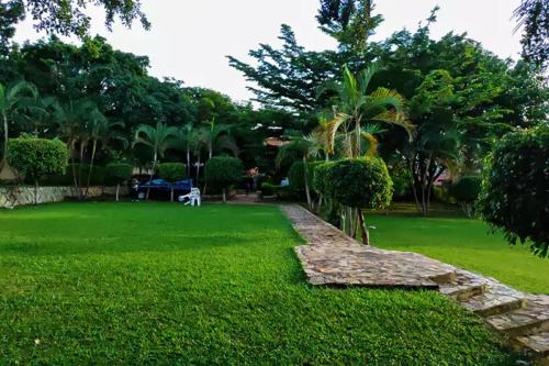 a green yard with a stone path in the grass at Conbary Hotel in Wakiso