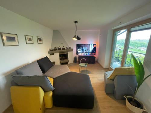 Apartma Slatina في Šmartno ob Paki: غرفة معيشة مع أريكة وكراسي ومدفأة