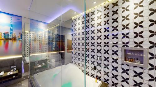 a bathroom with a glass wall with a tiled wall at Motel DUBAI BH in Belo Horizonte