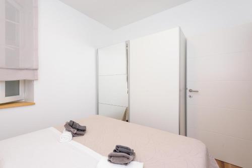 a bedroom with a bed with two slippers on it at Apartmani Boras in Metković