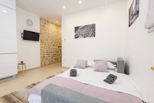 - une chambre avec un grand lit et des oreillers violets dans l'établissement Apartmani Boras, à Metković