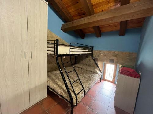- une chambre avec des lits superposés dans une maison dans l'établissement El horno Albergue Manzanos, à Manzanos