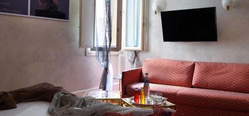 a living room with a red couch and a table at Art Hotel Orologio in Bologna