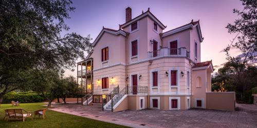a large white building with a tower at Sunset English Villas in Patra