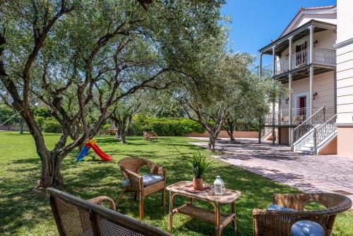 a yard with chairs and a table and a playground at Sunset English Villas in Patra