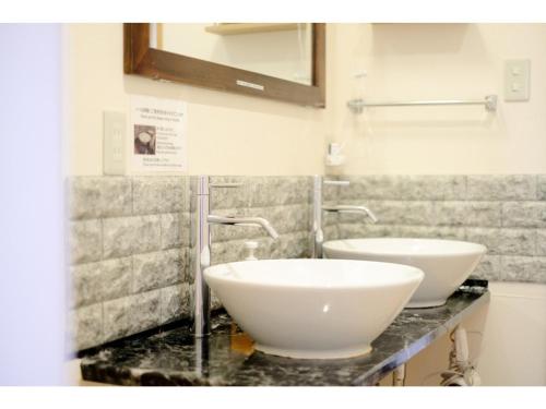 - une salle de bains avec 2 lavabos blancs sur un comptoir dans l'établissement Tottori Guest House Miraie BASE - Vacation STAY 41214v, à Tottori