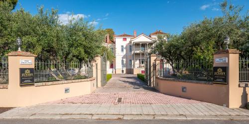 a house with a gate in front of a street at Sunset English Villas in Patra