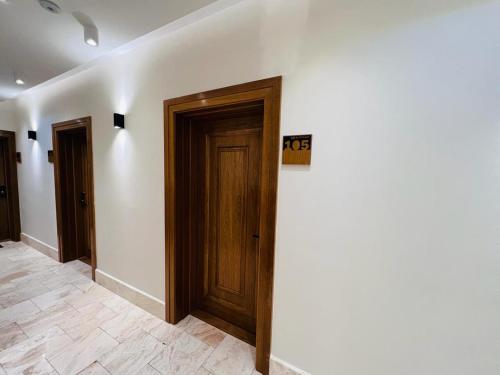 a hallway with two doors and a sign on a wall at Diamond in Palić