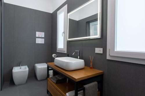 a bathroom with a sink and a toilet and a mirror at Il Giardino Antico in Agrigento