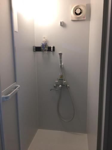 ein Bad mit einer Dusche mit einem Schlauch an der Wand in der Unterkunft Accommodation Service - Vacation STAY 43779v in Miyazaki