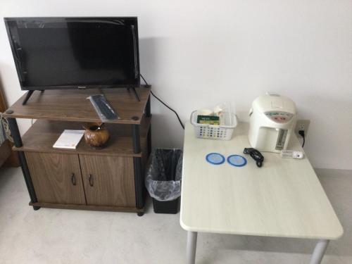 Accommodation Service - Vacation STAY 43779v في ميازاكي: غرفة مع طاولة مع تلفزيون على منصة