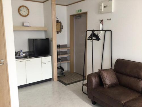 Accommodation Service - Vacation STAY 43779v في ميازاكي: غرفة معيشة بها أريكة وتلفزيون