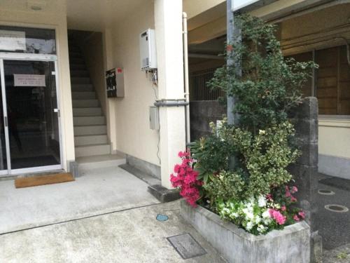 un edificio con flores en la parte delantera en Accommodation Service - Vacation STAY 43779v en Miyazaki