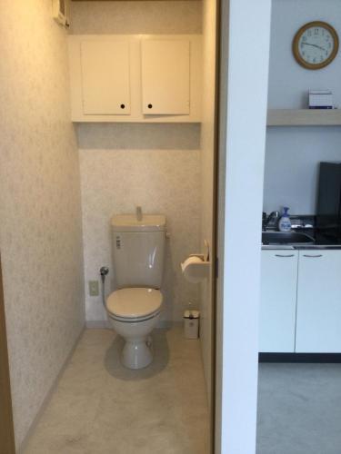 Accommodation Service - Vacation STAY 43779v في ميازاكي: حمام مع مرحاض وساعة على الحائط