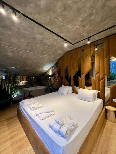 a bedroom with a large bed with towels on it at Rose Boutique Hotel in Tirana