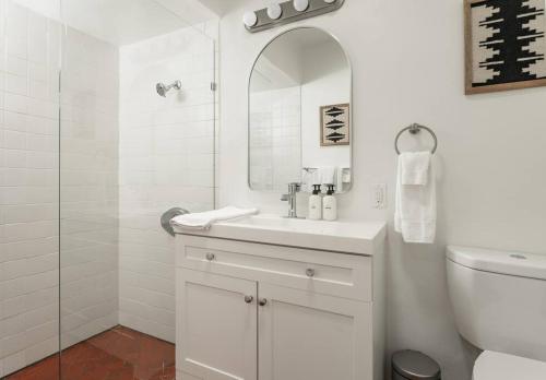 a white bathroom with a sink and a mirror at Cozy New - Casa Blanca Suite B1 in Montecito