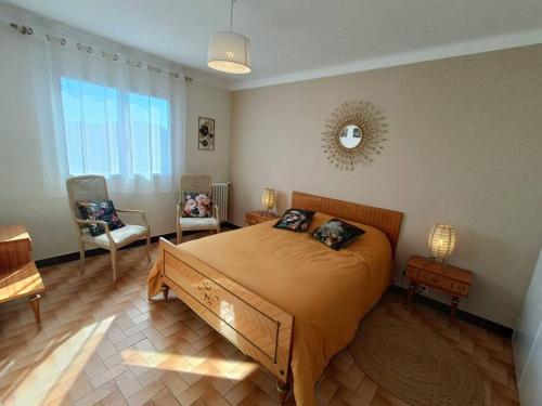 - une chambre avec un grand lit et deux chaises dans l'établissement Villa le Yucca proche des plages catalanes, à Bompas