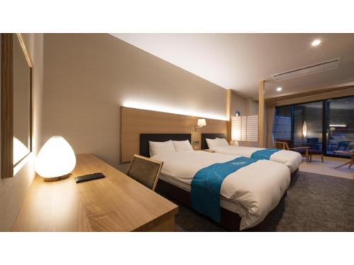 um quarto de hotel com uma cama e uma secretária com um candeeiro em Hotel Sekisuien - Vacation STAY 44693v em Gujo